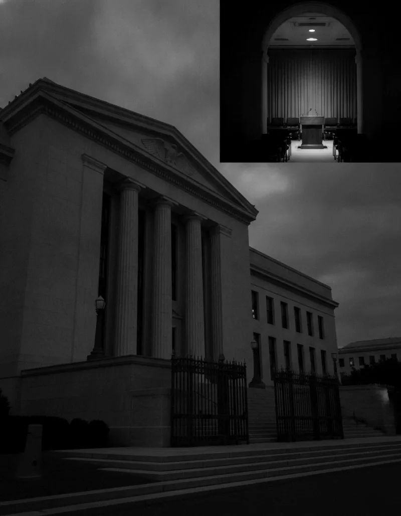 The Federal Reserve building in Washington stands imposing at dusk beside an empty, dimly lit press room lectern.